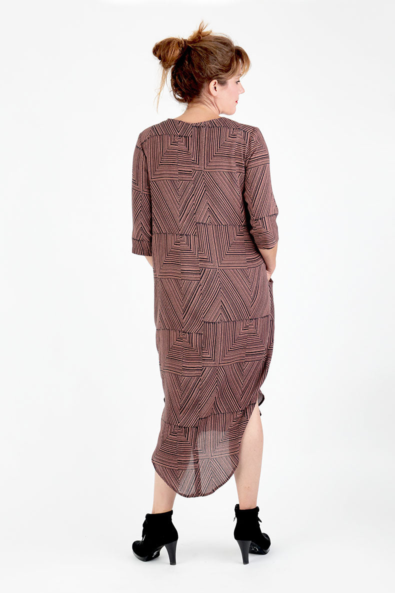 Mit dem Rücken zur Kamera steht eine Frau und präsentiert ihr selbst genähtes Kleid