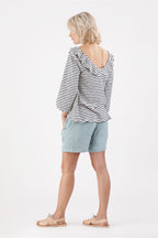 die Rückansicht einer Frau, die ein gestreiftes Oberteil und Shorts trägt.