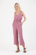 eine Frau welche die Hände in den Taschen ihres Jumpsuits versteckt