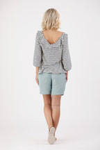 Rückenansicht einer Frau welche ein Shirt und Shorts trägt