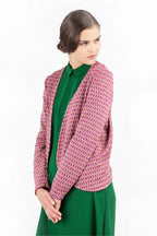eine Frau mit gegellten Haaren trägt ihre selbst genähte schön gemusterte Strickjacke