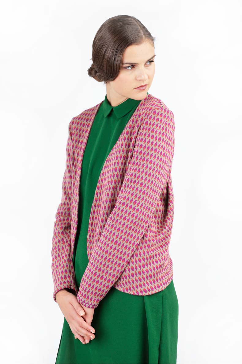 eine Frau mit gegellten Haaren trägt ihre selbst genähte schön gemusterte Strickjacke