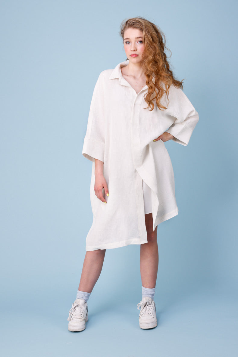 eine Junge Dame posiert mit ihrem selbst genähten Kleid vor einem blaue Hintergrund