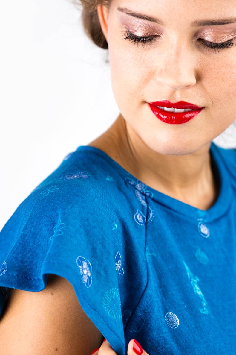 Nahaufnahme einer Frau welche ihr selbst genähtes Kleid bewundert
