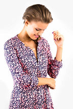 eine Frau blickt lächelnd an ihrer selbst genähten Tunika herunter